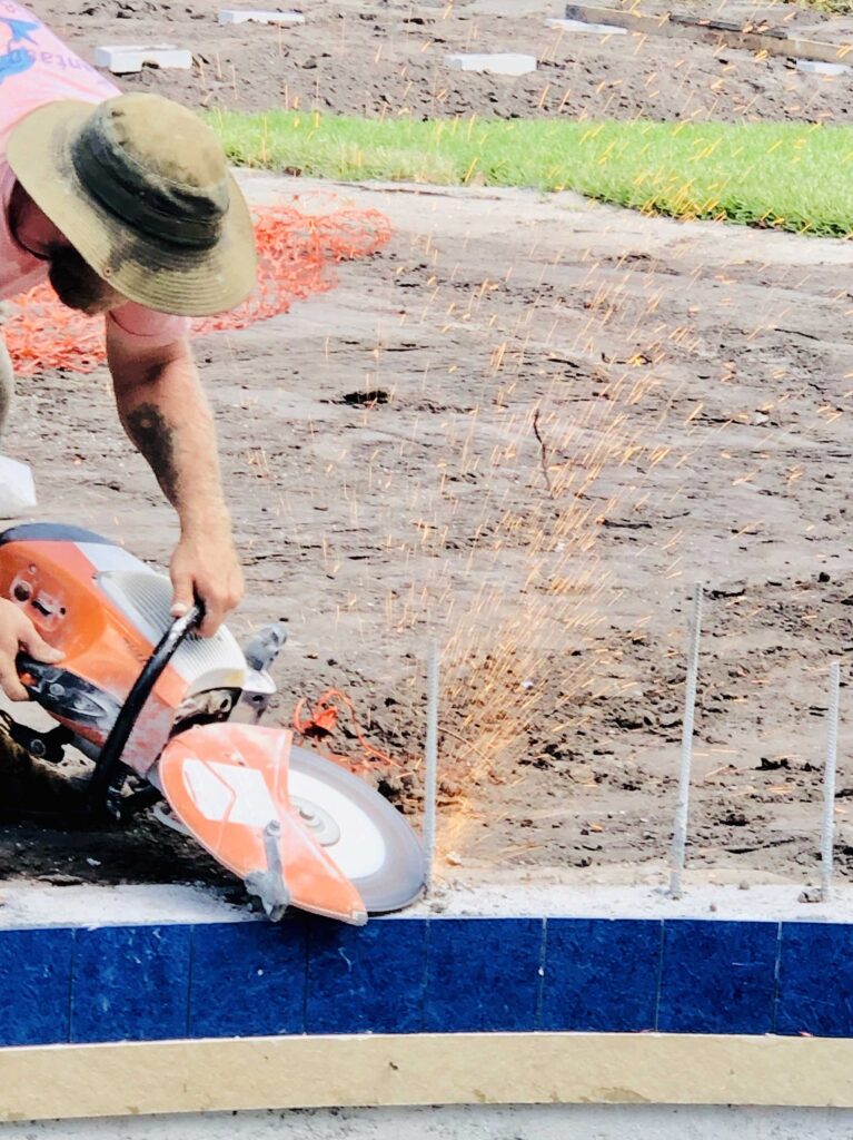 A construction worker cutting the bars with a circular saw machine.